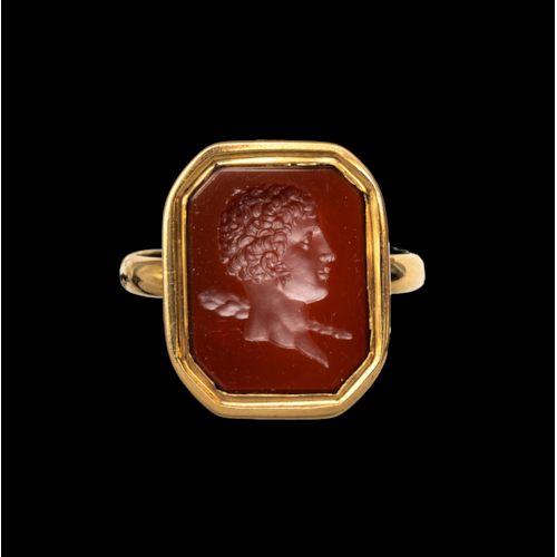 A 19th century gold ring set with a neoclassical carnelian intaglio. Bust of young Hercules.